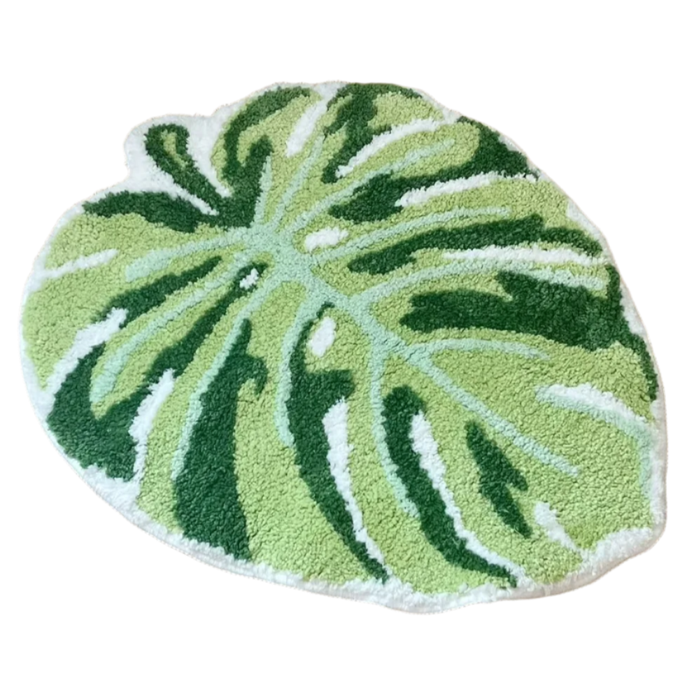 Hand-tufted green monstera leaf rug with natural split pattern.