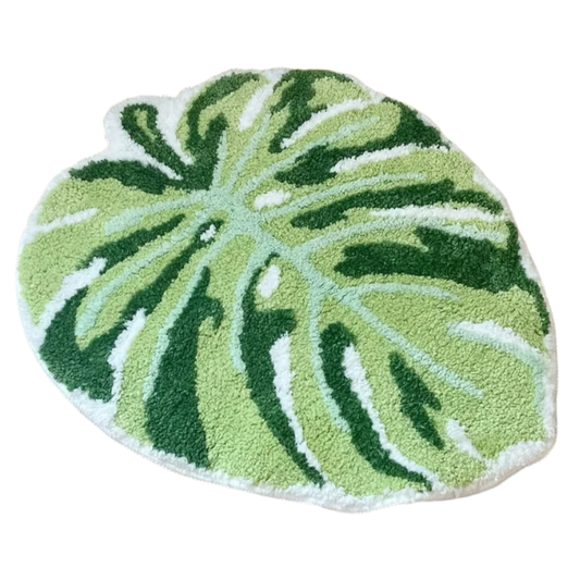 Hand-tufted green monstera leaf rug with natural split pattern.
