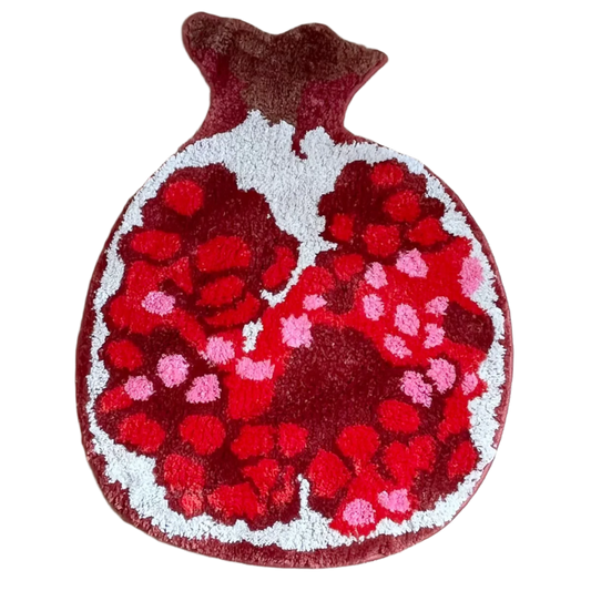 Rug shaped like a sliced pomegranate with vibrant seeds and red skin.