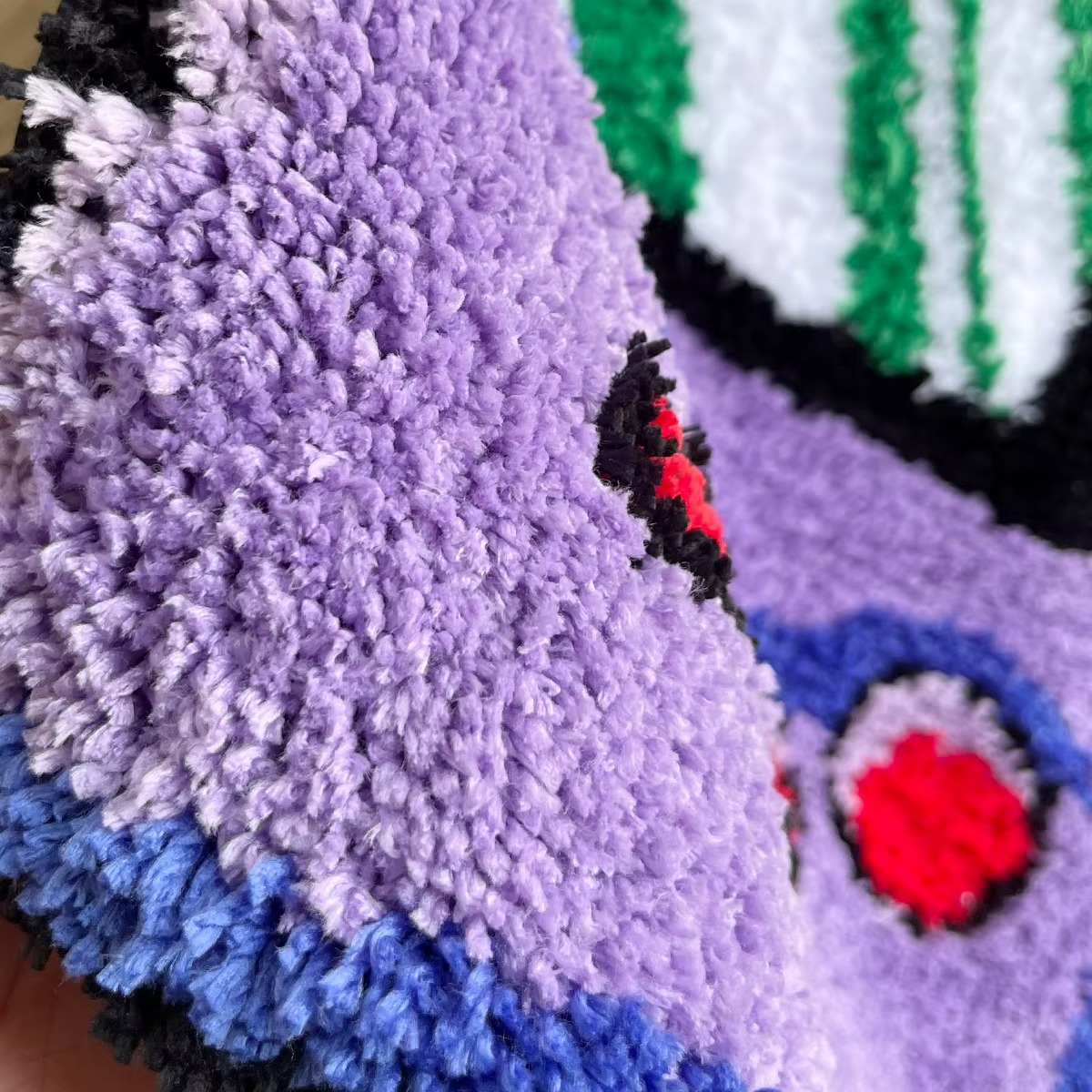 Close-up of the purple Gameboy Color tufted rug showing detailed texture and vibrant stitching