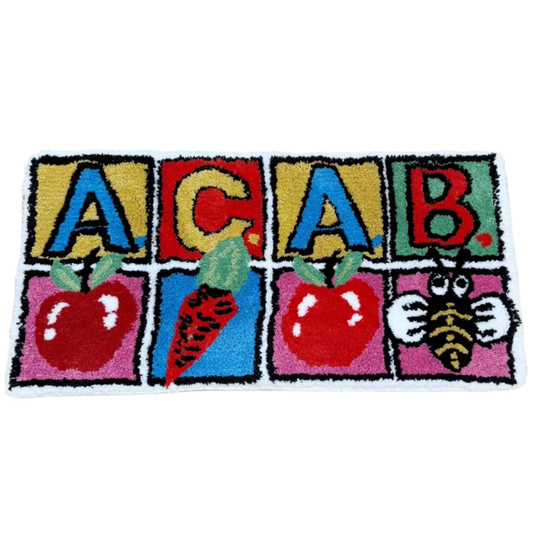 Tufted Rug with Children's block letters A-C-A-B with apple, carrot, apple, bumblebee illustrations underneath.