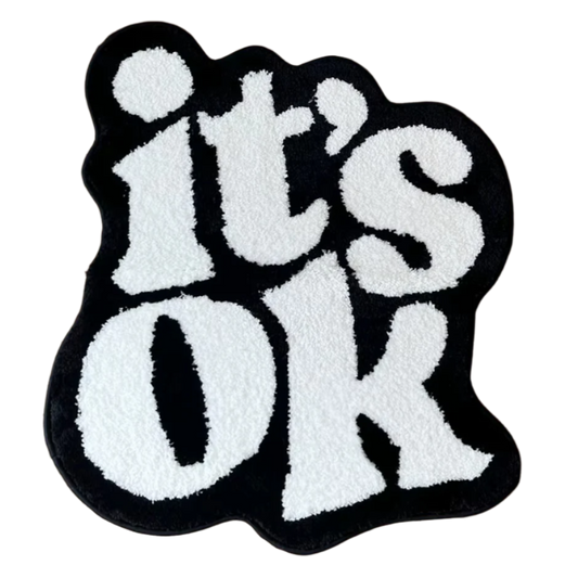 Minimalist tufted rug with "It’s Ok" text in soft neutral font.